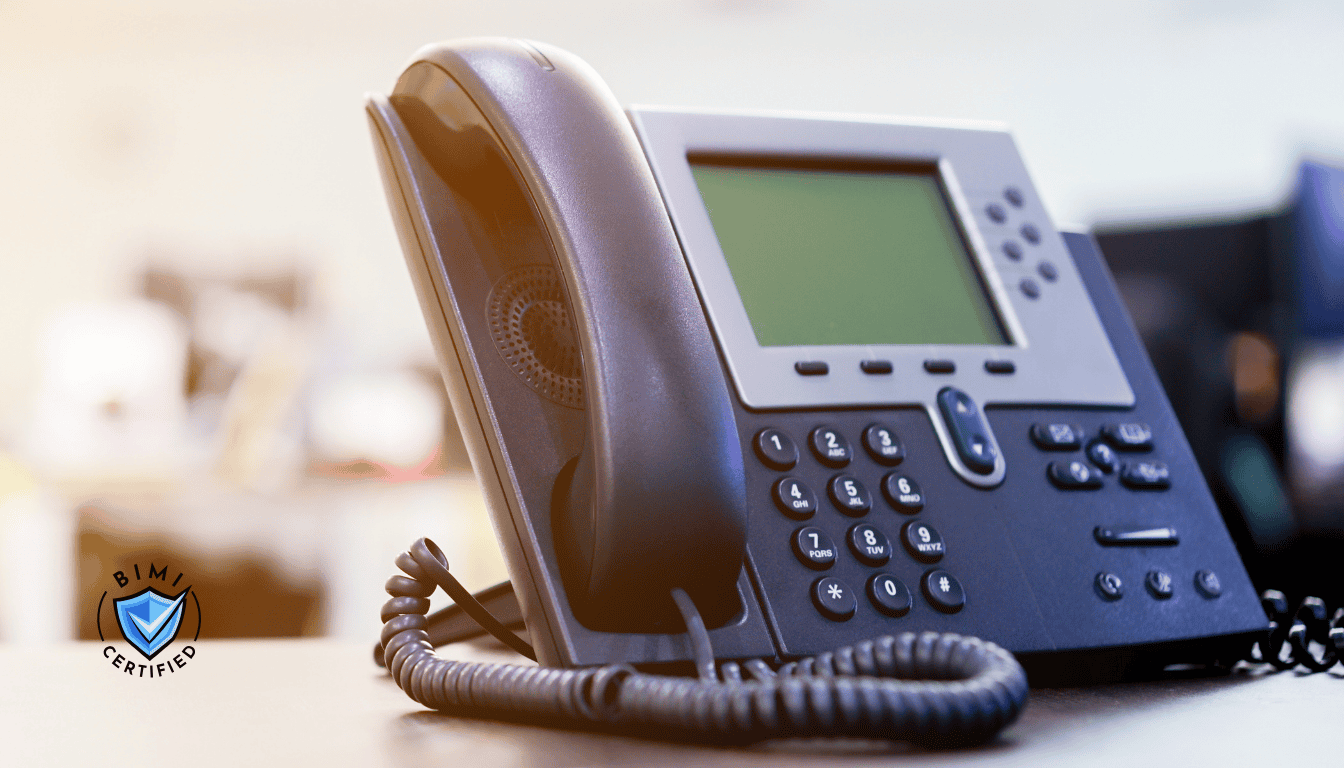 En moderne telefon på skrivebordet i påvente av en BIMI-verifiseringssamtale